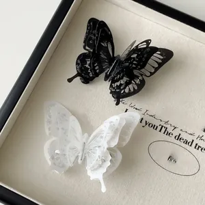 Detailed macro view of 3D layered butterfly hair clips with silver glitter details