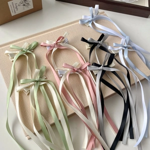 Detail of sweet ballet-style long ribbon bow hair clips in various pastel colors