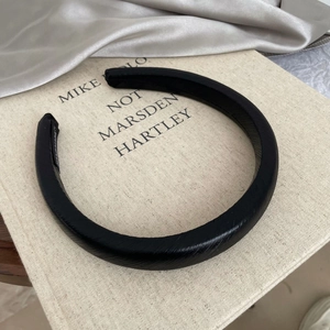 Macro detail of black leather thick headband with cross-hatch texture on a book