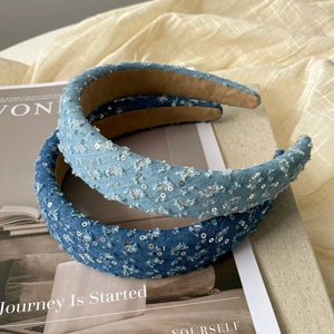 Detail of blue denim headbands with sequins and frayed edges on a vintage magazine