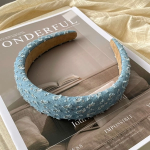 Detailed texture of blue denim headband with silver sequins and soft suede lining