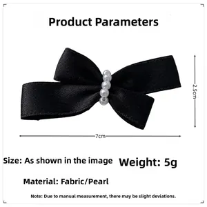 Detail view of a black ribbon bow hair clip with faux pearl accents and size dimensions