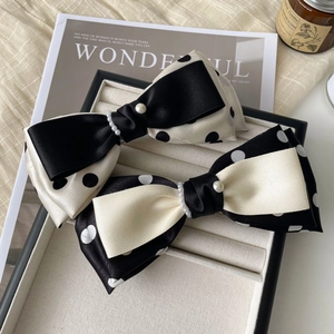 Detail von eleganten schwarz-weißen Polka-Dot-Haarschleifen mit Perlenakzenten
