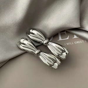 Detailed macro view showing the glossy silver metal texture and elegant ribbon bow design