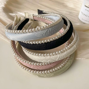 Detailed close-up of colorful jacquard sponge headbands with elegant pearl embellishments
