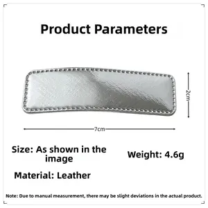 Detail of silver faux leather hair clip showing 7cm by 2cm size and stitching quality