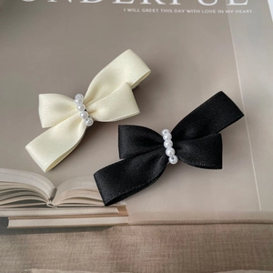 Elegant pearl bow hair clip set in black and cream satin for a sophisticated look