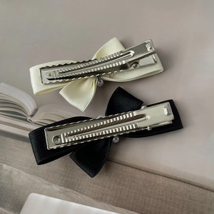 Detail of silk satin bow hair clips with pearls and silver metal alligator clips