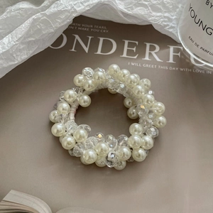 Gros plan sur l'élastique à cheveux avec perles blanches et perles en cristal taillées