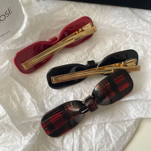 Detailed set of three bow hair clips in red, black, and tartan plaid patterns