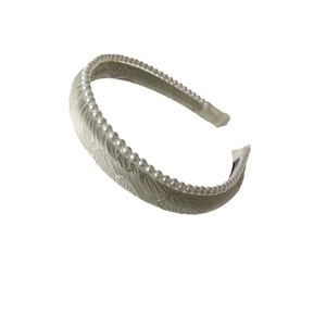 Champagne jacquard padded headband with delicate pearl trim on a white background