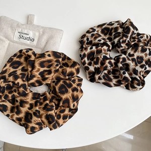 Two-pack of elegant leopard print scrunchies in brown and grey tones on white surface