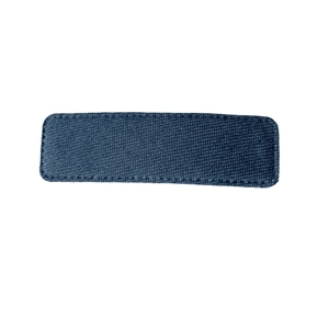 Blue denim fabric rectangular hair clip with fine stitching on a clean white background