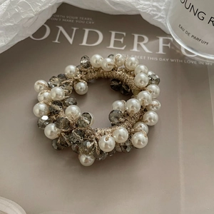 Élastique à cheveux élégant avec perles et cristaux sur un magazine, éclairage doux