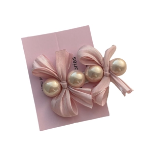 Barrette à cheveux élégante en satin rose avec perles sur carte de présentation