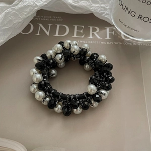 Détail de l'élastique à cheveux avec perles blanches et perles de cristal noir
