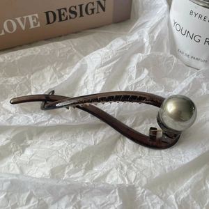 Detail of dark brown resin hair clip featuring a large grey metallic pearl ornament
