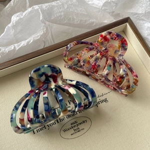Détails de deux pinces à cheveux en acétate coloré avec motifs floraux pour cheveux épais