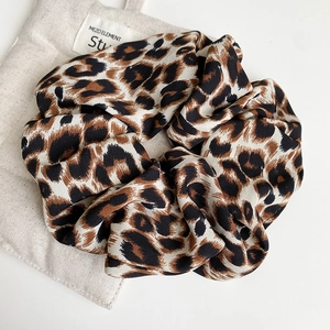 Close-up of a large leopard print scrunchie with soft chiffon texture and elastic band
