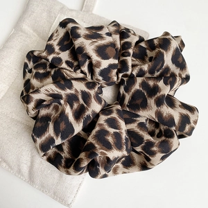 Detailed macro view of leopard print oversized hair scrunchie with soft twill fabric texture