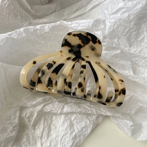 Détail de la pince à cheveux en acétate en forme de coquille au motif écaille de tortue