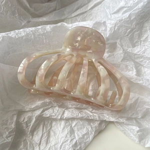 Détail d'une grande pince à cheveux en acétate marbré rose et blanc pour cheveux épais