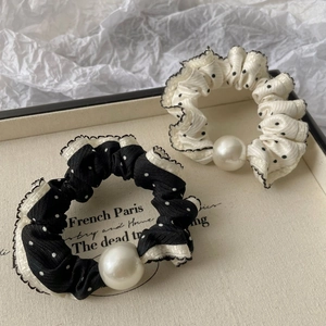Detail of polka dot scrunchies with large pearl accents in a stylish display box