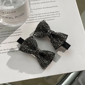 Close-up of black rhinestone bow hair clips with a sparkling diamond finish