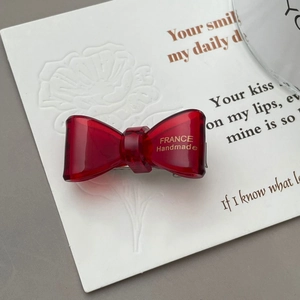 Macro shot of red translucent acetate hair clip with gold France Handmade logo