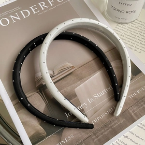 Close-up of black and silver thin headbands with sparkling rhinestones on a magazine