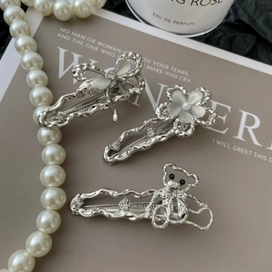 Détails des barrettes en métal liquide argenté avec motifs de papillon, fleur et ours