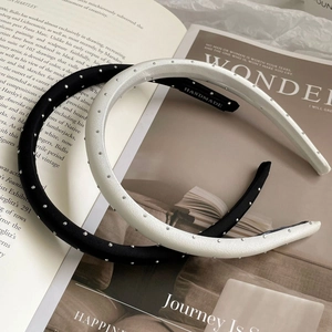Detail of handmade black and white headbands with shimmering rhinestones on books