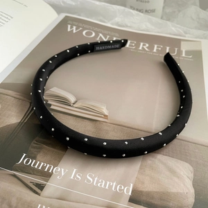 Detail of black padded headband with sparkling silver rhinestones on a fashion magazine