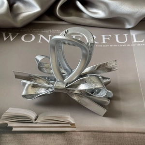 Elegant silver bow hair claw clip with metallic leather texture for women's hair styling