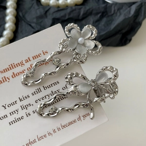 Détails de barrettes argentées à texture de lave avec fleurs et papillons en opale