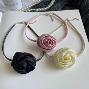 Three elegant rose flower chokers in black, pink, and beige with silk fabric texture