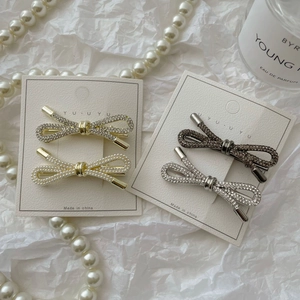 Set van vier luxe haarspelden met strass strikjes en parels op witte kaart