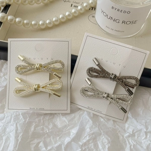 Sprankelende haarspelden met strass en parels in goud en gunmetal op displaykaart
