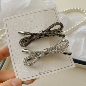 Detailweergave van zilveren en gunmetal strass strik haarspeldjes op een kaartje