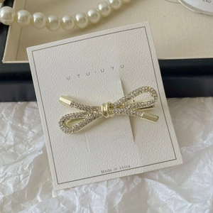 Detail van een gouden metalen strik haarclip met fonkelende strassteentjes op display
