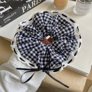 Chouchou à carreaux noir et blanc avec dentelle et nœud en ruban noir sur manche blanche