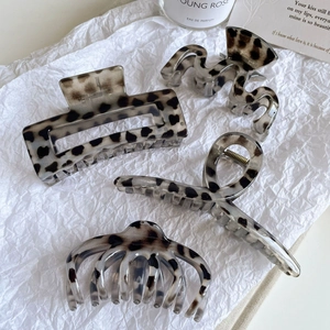 Ensemble de quatre pinces à cheveux à motif léopard écaille de tortue sur tissu blanc