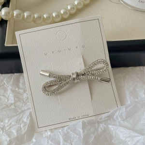 Detail van een zilveren metalen strik haarclip met volledige diamanten inlegwerk