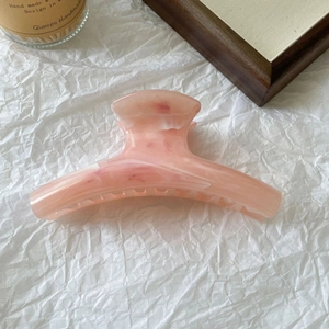 Detail view of large marble texture acetate hair claw clip with non-slip teeth for buns