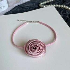 Detailed macro view of a pink satin rose choker with pink faux leather strap and lobster clasp