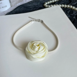 Detailed close-up of a creamy white satin rose choker with an adjustable metal chain