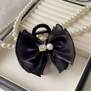 Macro de la pince à cheveux noeud en satin noir avec strass carrés et perles