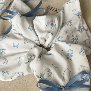 Detail shot of the large white fabric scrunchie with blue cat prints and ribbon bows