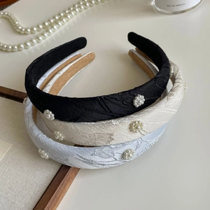 Detailed view of vintage wide headbands with jacquard fabric and pearl flower patterns
