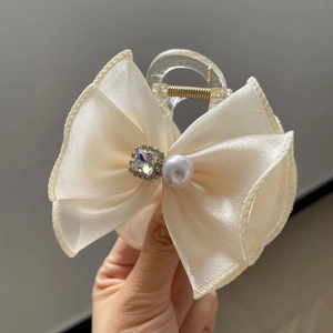 Détail d'une grande pince à cheveux en satin crème avec strass et accents de perles